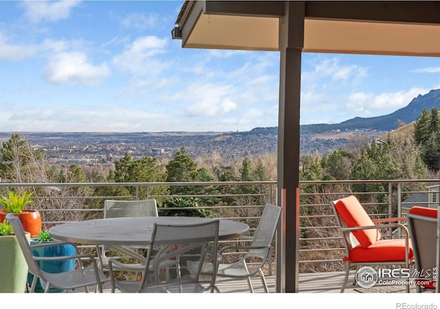 balcony with outdoor dining area and a mountain view