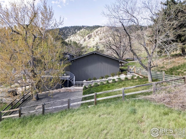 view of home's exterior featuring fence and a mountain view