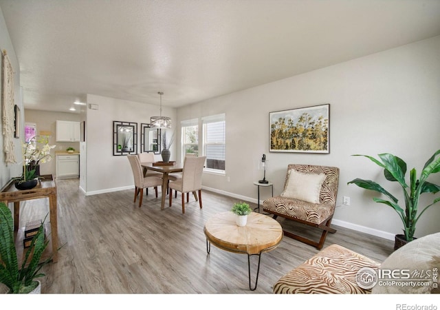 living area featuring baseboards and light wood finished floors