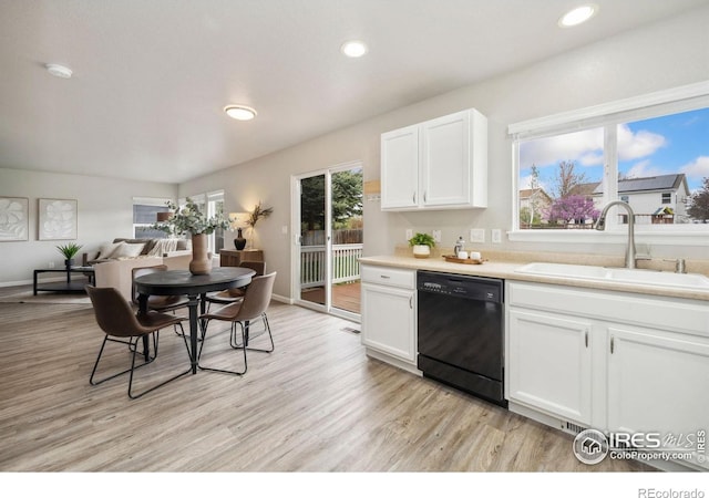 kitchen with white cabinets, a sink, light wood-style floors, black dishwasher, and recessed lighting