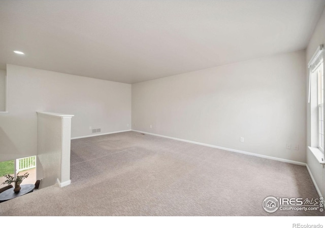 empty room with baseboards, carpet flooring, recessed lighting, and visible vents