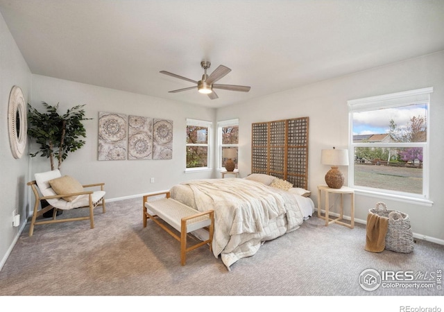 carpeted bedroom featuring baseboards, multiple windows, and a ceiling fan