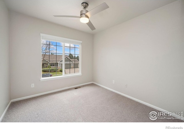 spare room featuring carpet floors, baseboards, a ceiling fan, and visible vents