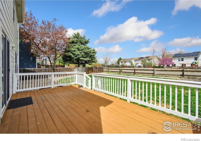 deck with a fenced backyard, a yard, and a residential view