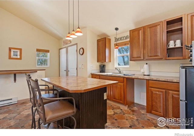 kitchen with a breakfast bar area, vaulted ceiling, brown cabinetry, and light countertops