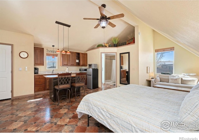 bedroom with freestanding refrigerator, vaulted ceiling, and multiple windows