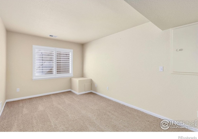 carpeted spare room with baseboards and visible vents