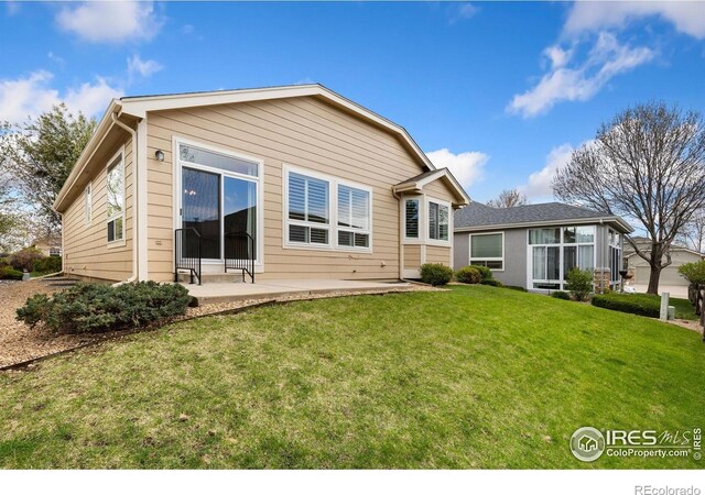 rear view of house featuring a yard and a patio area