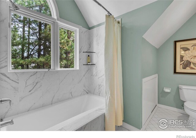 2672 Winding Trail Dr, Boulder, CO 80304 - bathroom featuring vaulted ceiling, a tub with marble appearance, toilet, plenty of natural light, and curtained shower