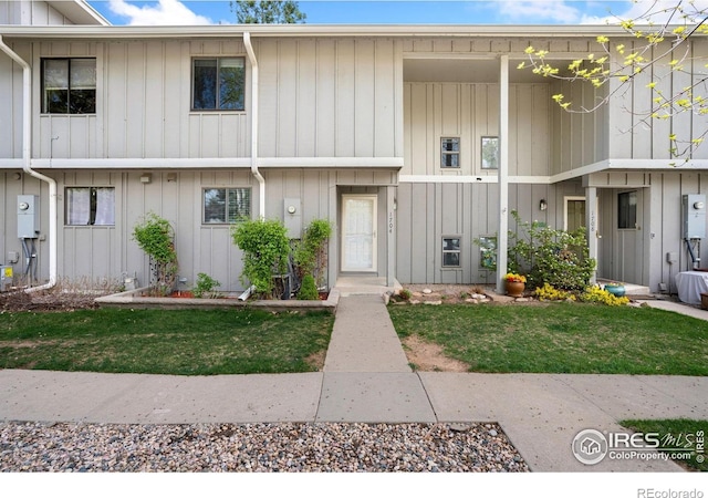 multi unit property with board and batten siding and a front yard
