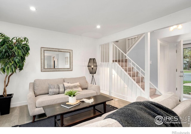 living area featuring recessed lighting, baseboards, wood finished floors, and stairway