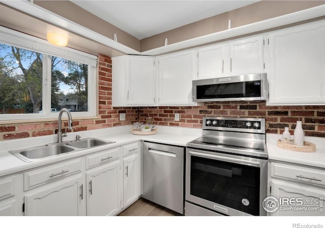 kitchen featuring white cabinets, stainless steel appliances, and a sink