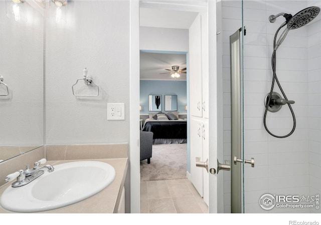 full bathroom featuring ceiling fan, a stall shower, tile patterned floors, vanity, and ensuite bath