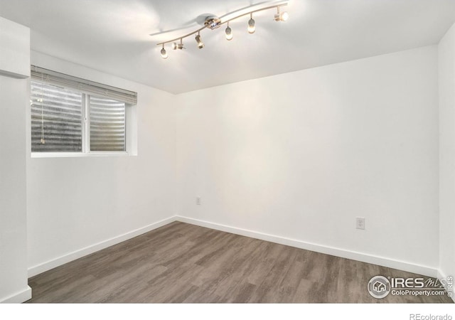 unfurnished room with baseboards and wood finished floors