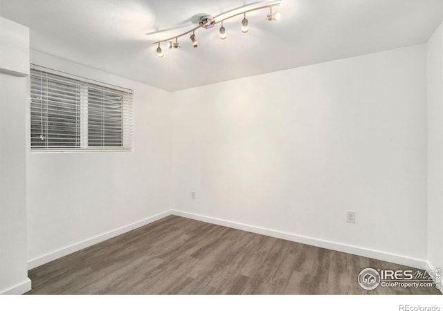 empty room featuring baseboards and wood finished floors