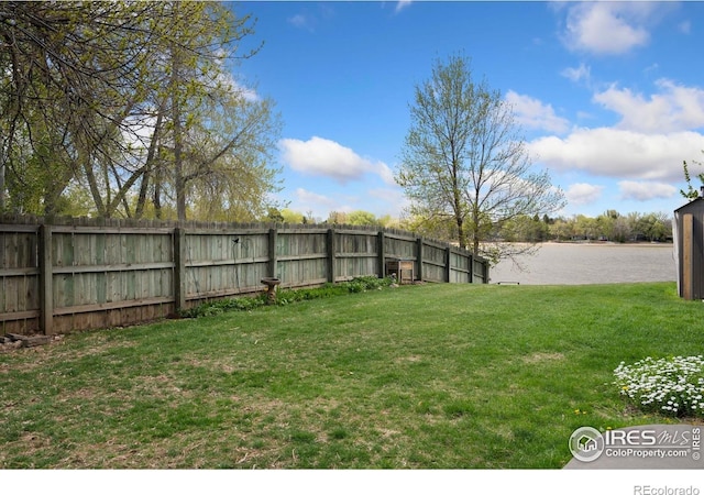view of yard featuring a water view and fence