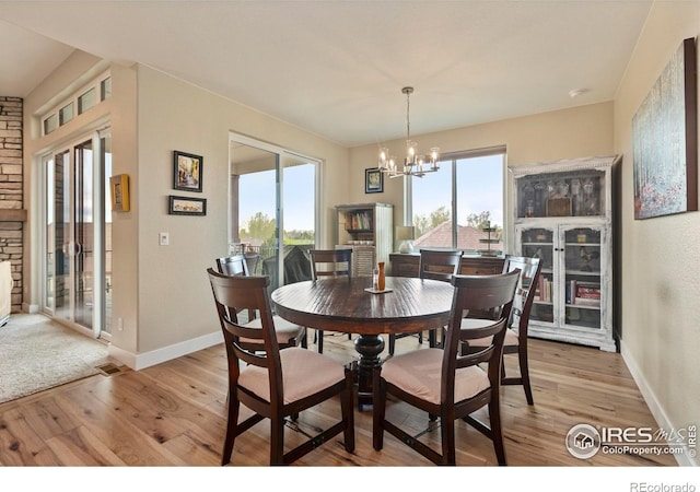 1603 Plank Ln, Fort Collins, CO 80524 - dining area with baseboards, a chandelier, plenty of natural light, and light wood-type flooring
