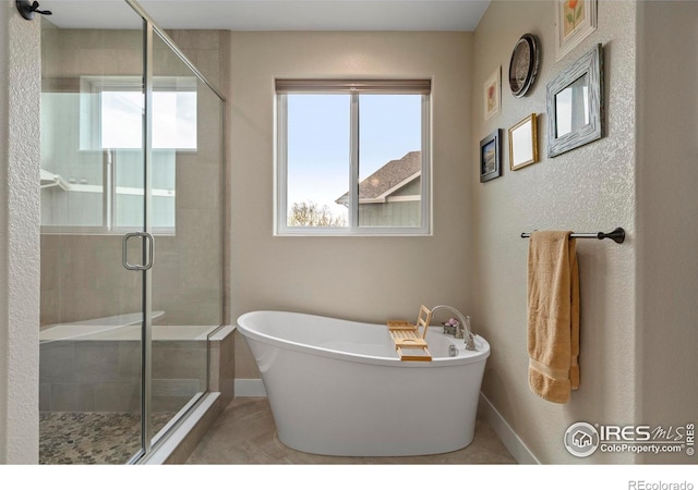1603 Plank Ln, Fort Collins, CO 80524 - bathroom featuring baseboards, a soaking tub, and a shower stall