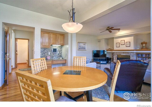 8574 W 94th Ave, Westminster, CO 80021 - dining room with a ceiling fan, light wood-type flooring, and a stone fireplace