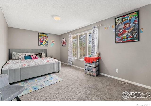 carpeted bedroom featuring visible vents, a textured ceiling, and baseboards