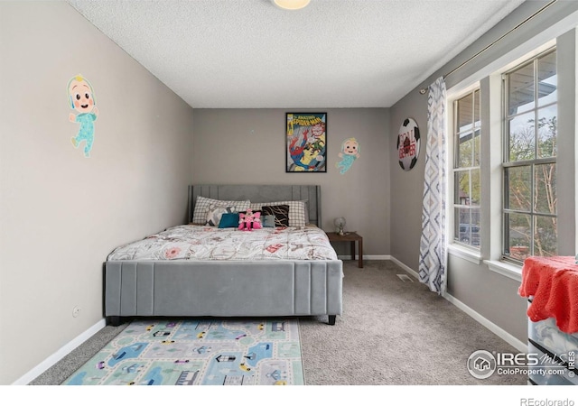 carpeted bedroom featuring a textured ceiling and baseboards