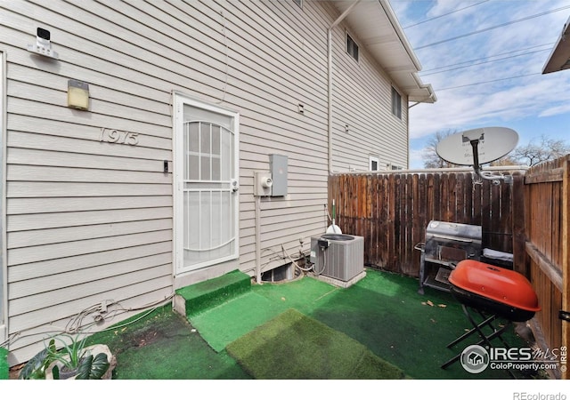 doorway to property with fence and central AC unit