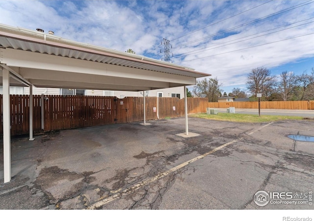 covered parking lot featuring fence