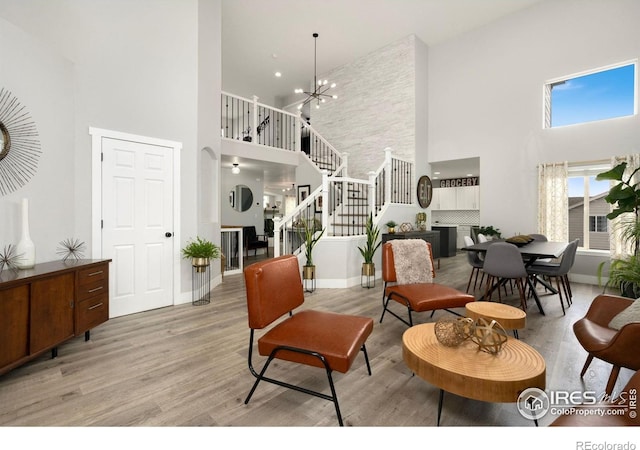 4400 Red Fox Ct, Loveland, CO 80537 - living area featuring light wood-style floors, baseboards, a towering ceiling, and stairway
