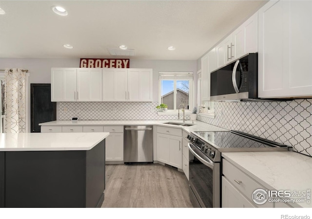 4400 Red Fox Ct, Loveland, CO 80537 - kitchen with a sink, white cabinets, stainless steel appliances, and light wood-type flooring