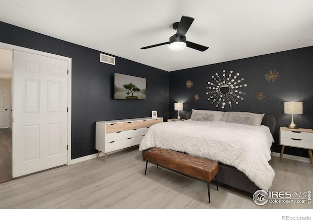 4400 Red Fox Ct, Loveland, CO 80537 - bedroom featuring an accent wall, baseboards, wallpapered walls, wood finished floors, and visible vents
