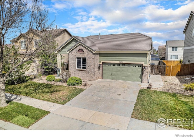 view of front of property with fence, a tile roof, brick siding, a garage, and driveway