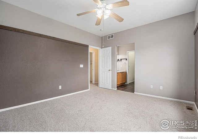 unfurnished bedroom with carpet floors, baseboards, ensuite bathroom, and visible vents