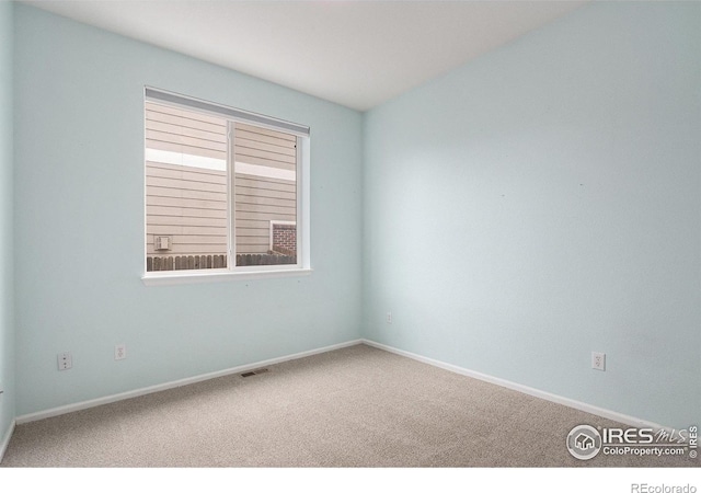 spare room featuring visible vents, carpet flooring, and baseboards
