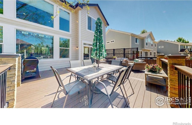 deck with outdoor dining area, a residential view, and an outdoor living space