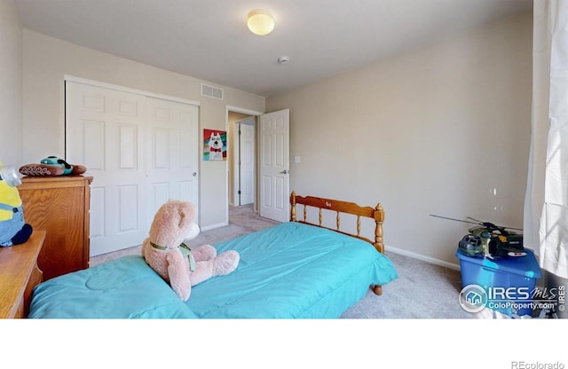 carpeted bedroom with a closet and baseboards