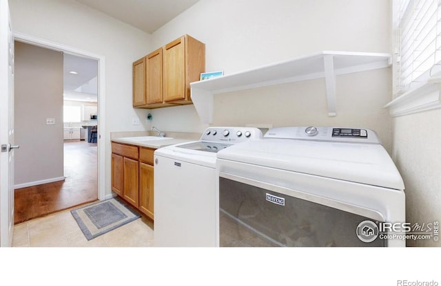 clothes washing area with independent washer and dryer, cabinet space, and light tile patterned floors