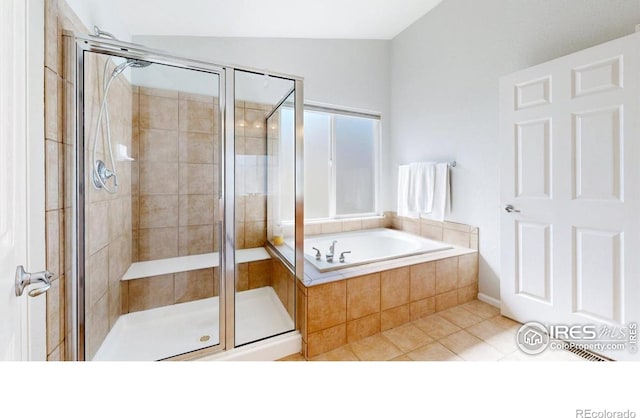 bathroom with a shower stall, tile patterned flooring, a bath, and lofted ceiling