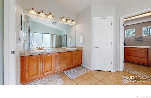 full bathroom with a shower stall, double vanity, tile patterned flooring, and baseboards