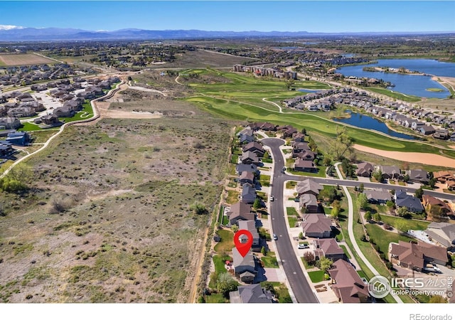 bird's eye view featuring a water and mountain view, view of golf course, and a residential view