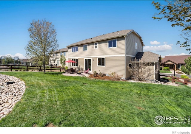 back of house featuring a lawn, a patio, and fence