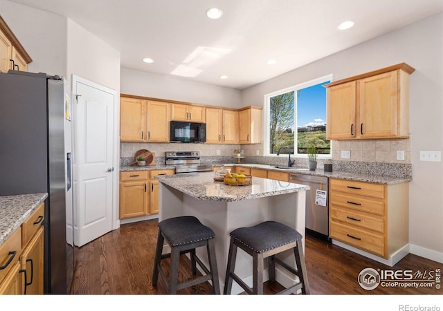 kitchen with stainless steel appliances, tasteful backsplash, a kitchen breakfast bar, and dark wood-style floors