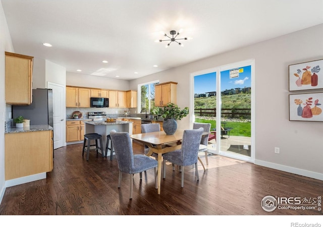 dining room featuring an inviting chandelier, dark wood-type flooring, baseboards, and recessed lighting