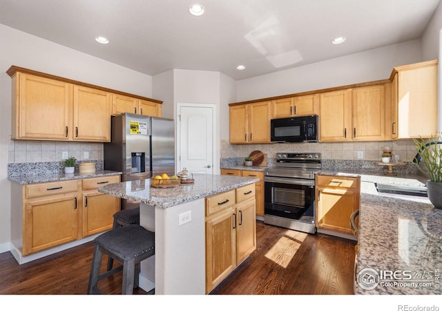 kitchen with dark wood-style flooring, stainless steel appliances, decorative backsplash, and a kitchen island