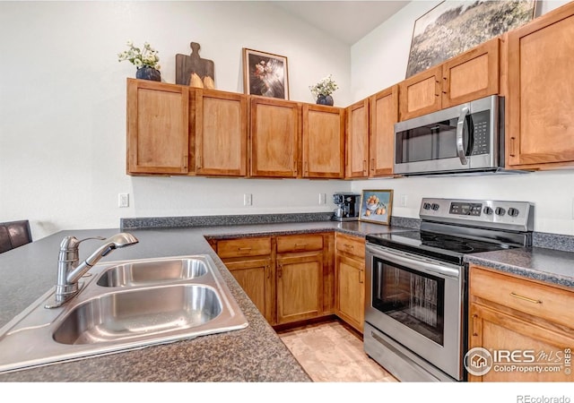 kitchen with a sink, dark countertops, and stainless steel appliances