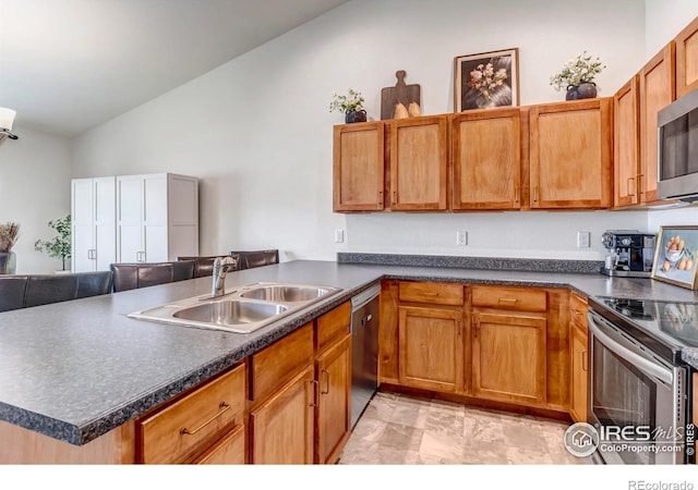 kitchen featuring dark countertops, appliances with stainless steel finishes, a sink, and vaulted ceiling