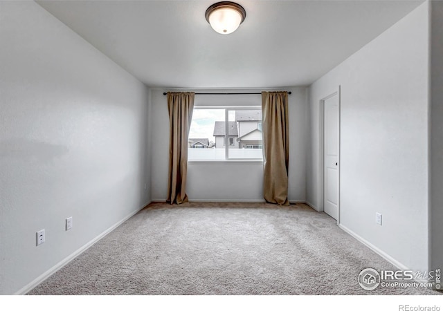 spare room with baseboards and carpet flooring