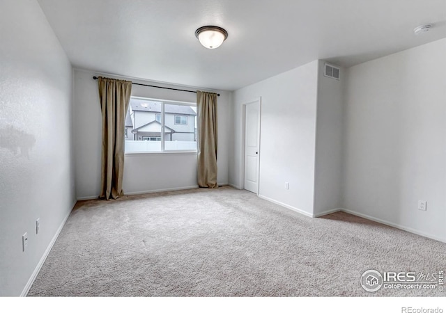 empty room featuring baseboards, carpet flooring, and visible vents