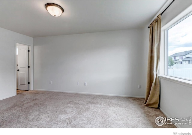 unfurnished room featuring carpet floors and baseboards