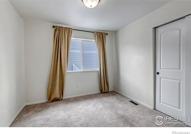 carpeted empty room with baseboards and visible vents