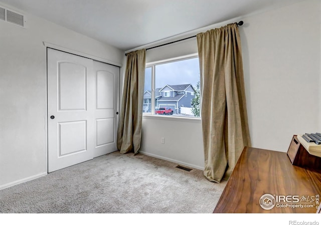 carpeted bedroom featuring baseboards, visible vents, and a closet